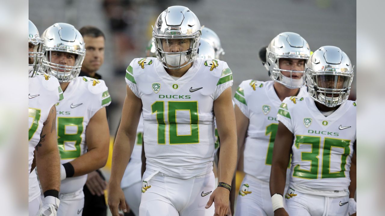 Justin Herbert Oregon Ducks Unsigned White Jersey Warming Up Photograph