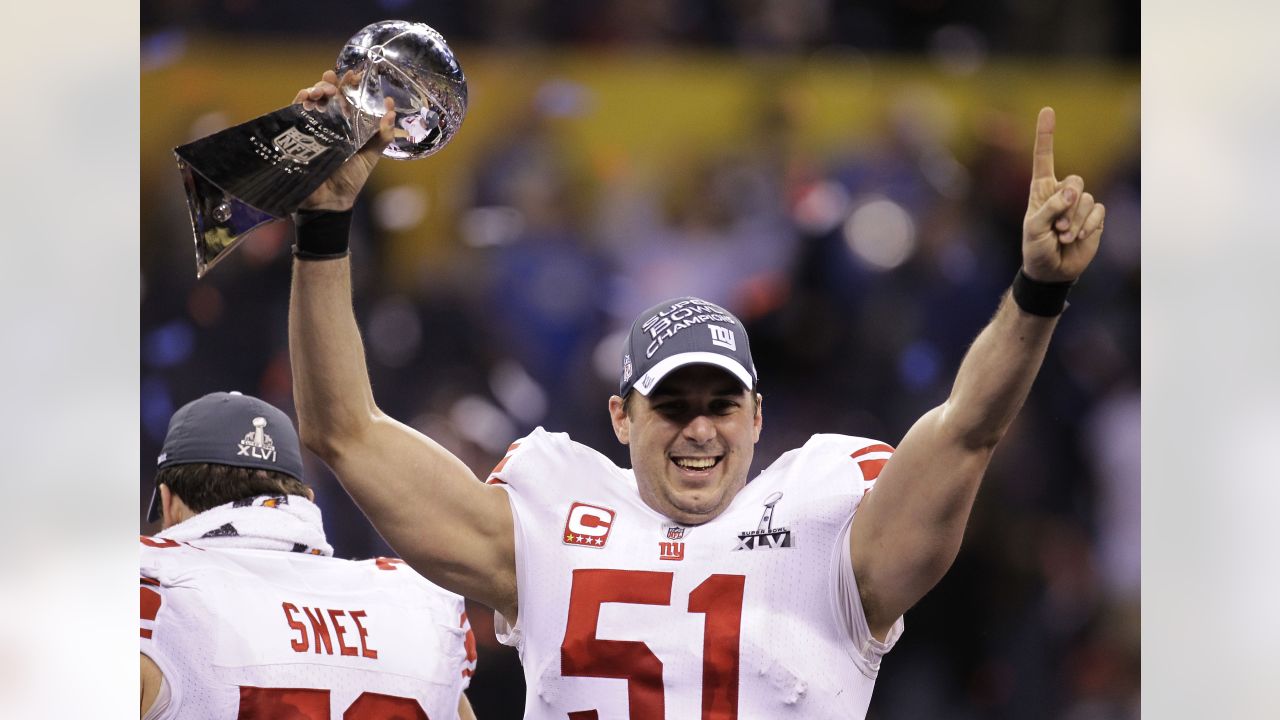 New York Giants wide receiver Devin Thomas, center, holds the Vince Lombari  trophy while teammates celebrate after defeating the New England Patriots  21-17 to win Super Bowl XLVI February 5, 2012, in