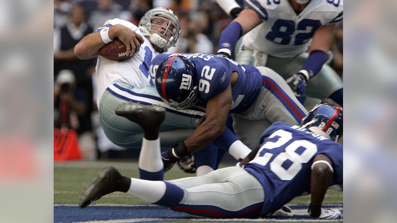 Dallas Cowboys Tony Romo gets pressured by New York Giants Michael Strahan  in the second half of their playoff game January 13, 2008 at Texas Stadium  in Irving, TX. The Giants beat