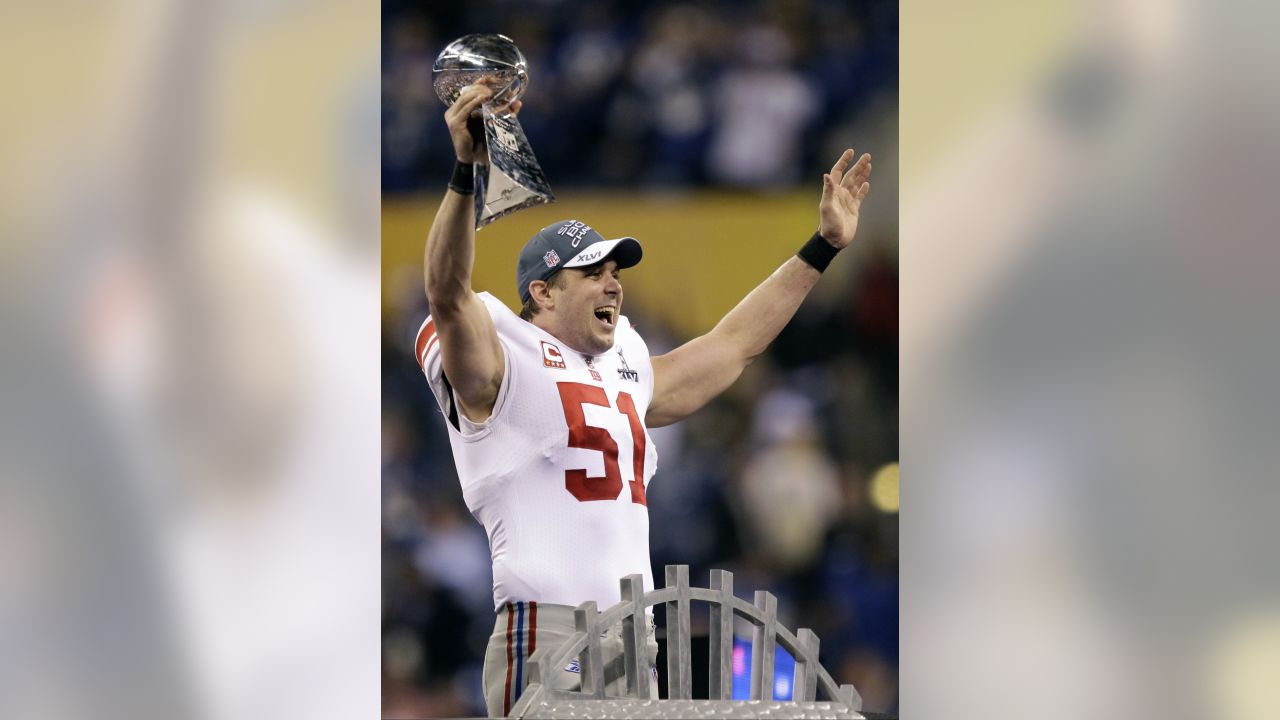 New York Giants line backer Zak DeOssie holds up a newspaper proclaiming  the Giants' win over the New England Patriots at Super Bowl XLII at  University of Phoenix Stadium in Glendale, Arizona