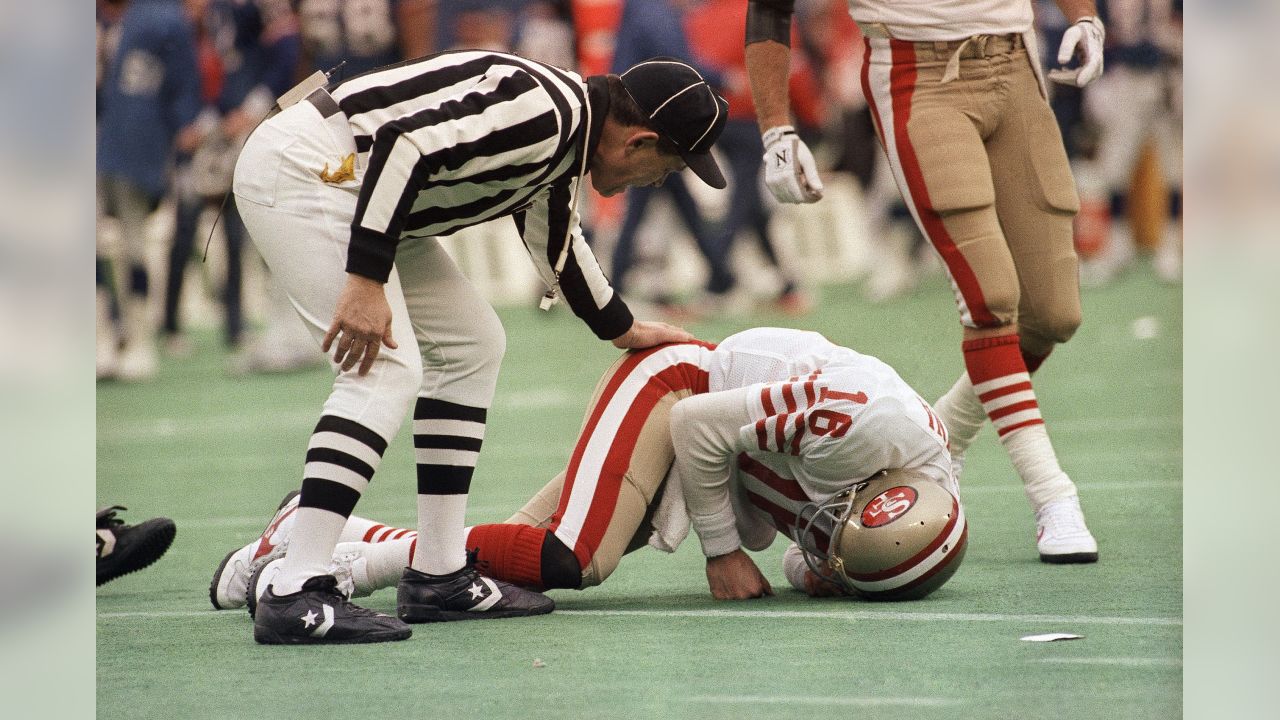 San Francisco 49ers QB Joe Montana kneeling with coach Bill Walsh