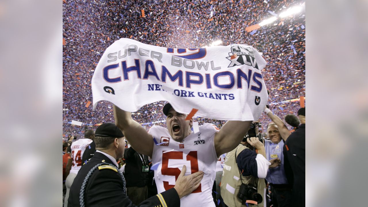 New York Giants line backer Zak DeOssie holds up a newspaper proclaiming  the Giants' win over the New England Patriots at Super Bowl XLII at  University of Phoenix Stadium in Glendale, Arizona