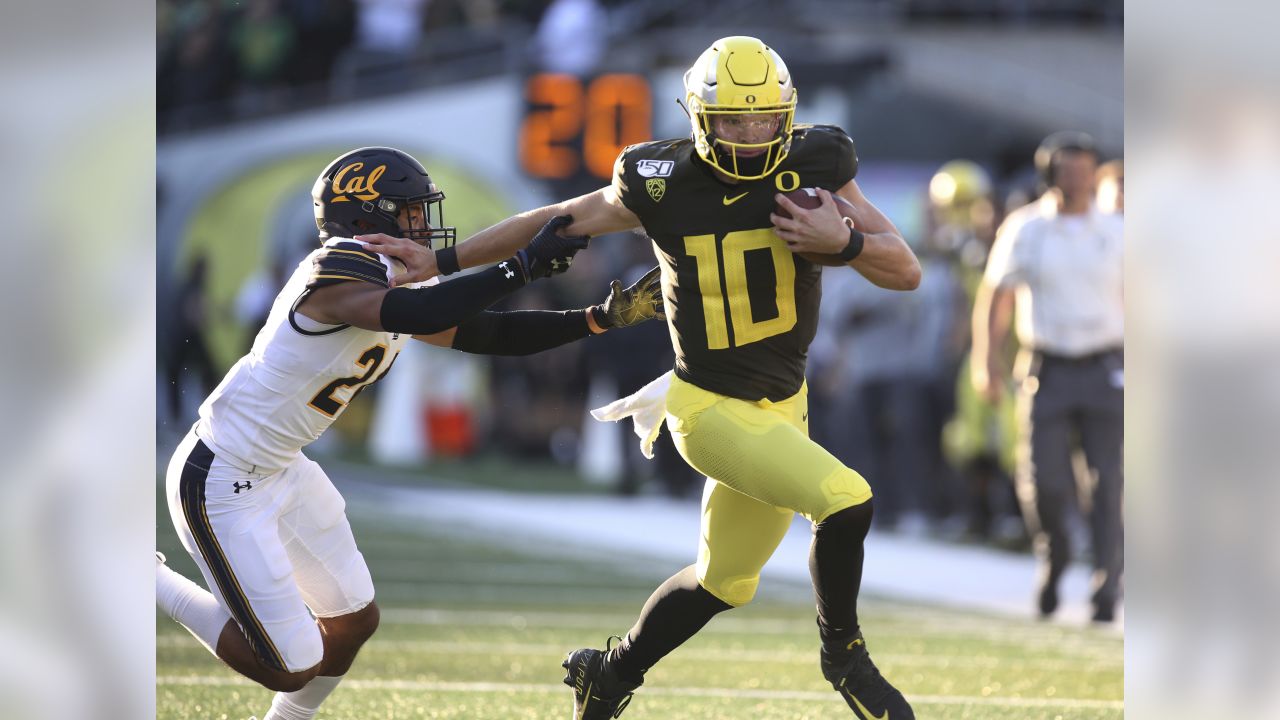 Justin Herbert of the Oregon Ducks runs with the ball in the first