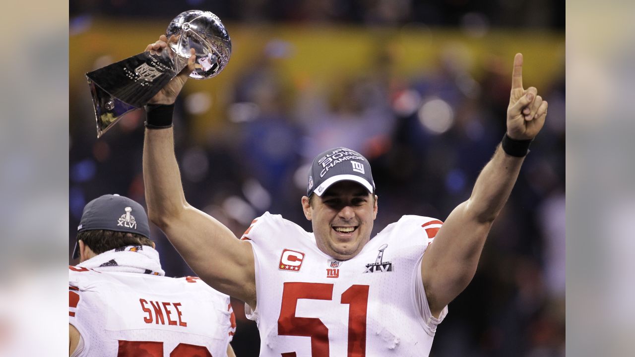 New York Giants line backer Zak DeOssie holds up a newspaper proclaiming  the Giants' win over the New England Patriots at Super Bowl XLII at  University of Phoenix Stadium in Glendale, Arizona