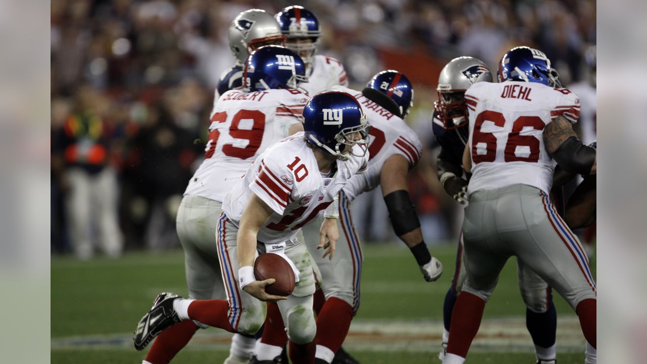 New York Giants quarterback Eli Manning escapes a sack by the New