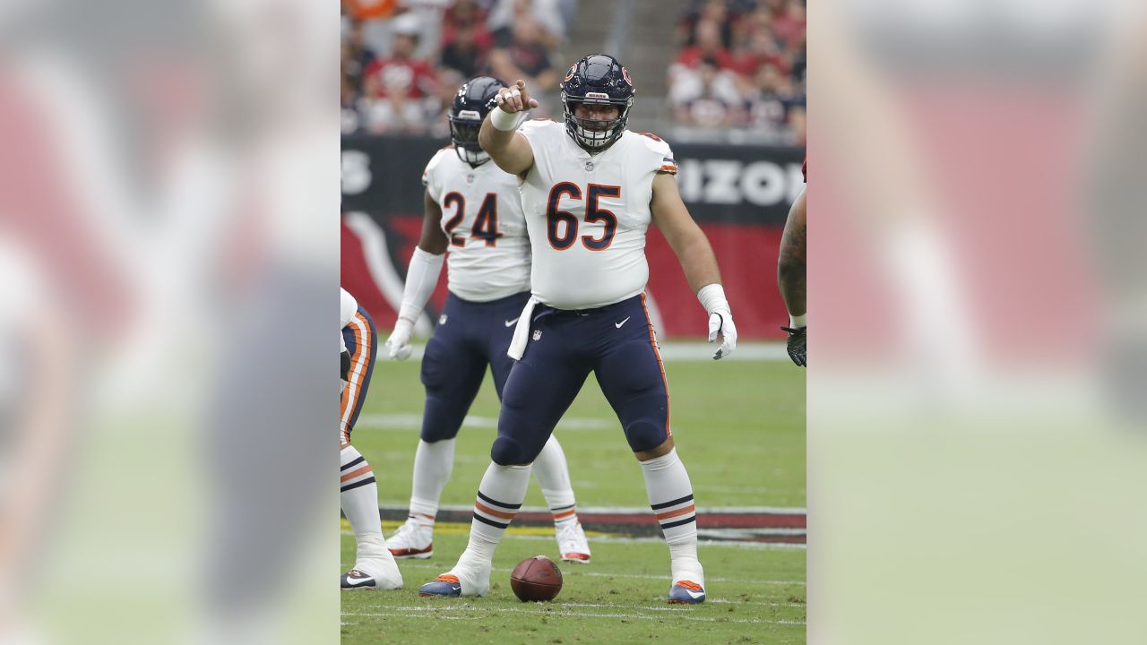 Chicago Bears center Cody Whitehair (65) and quarterback Justin Fields look  over the Tennessee Titans defense in an NFL preseason football game  Saturday, August 12, 2023, in Chicago. (AP Photo/Charles Rex Arbogast