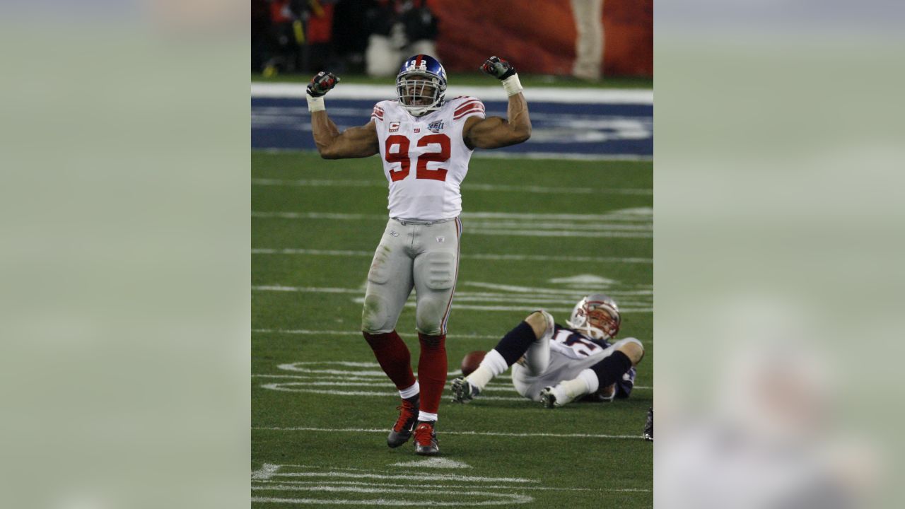 New York Giants wide receiver Devin Thomas, center, holds the Vince Lombari  trophy while teammates celebrate after defeating the New England Patriots  21-17 to win Super Bowl XLVI February 5, 2012, in