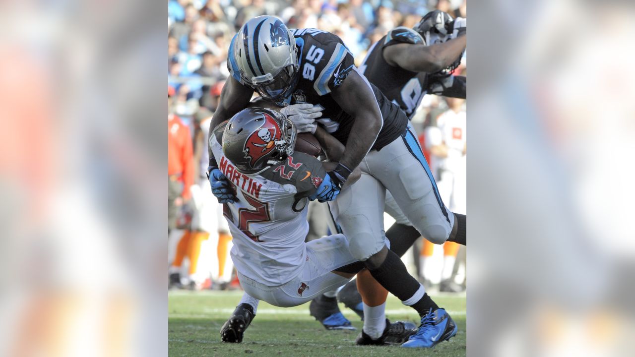 Carolina Panthers linebacker Thomas Davis lifts the NFC championship trophy  as he and defensive end Charles Johnson, left, celebrate after the Panthers  defeat the Arizona Cardinals 49-15 at Bank of America Stadium