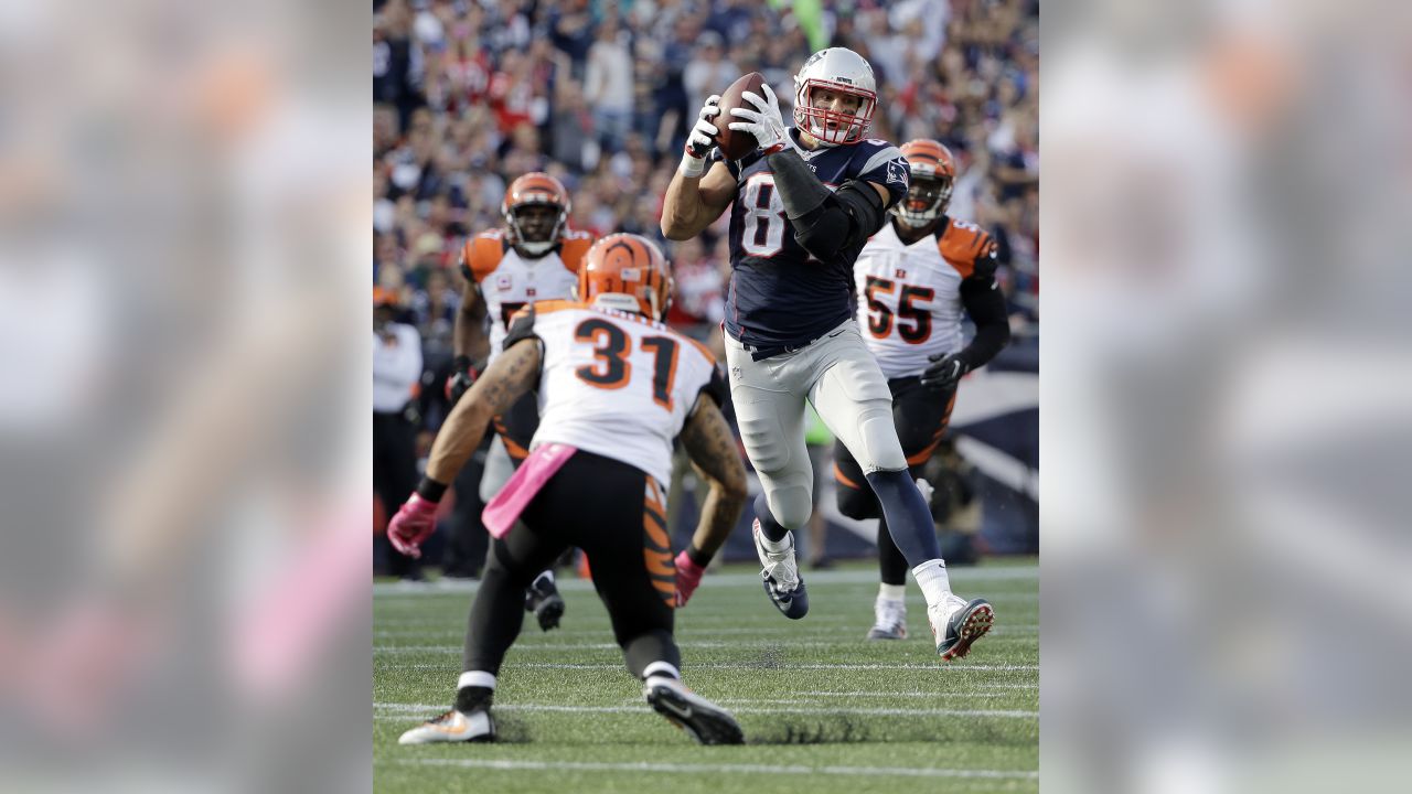 New England Patriots tight end Rob Gronkowski (87) runs from Cincinnati  Bengals defenders after catching a pass during the second half of an NFL  football game, Sunday, Oct. 16, 2016, in Foxborough