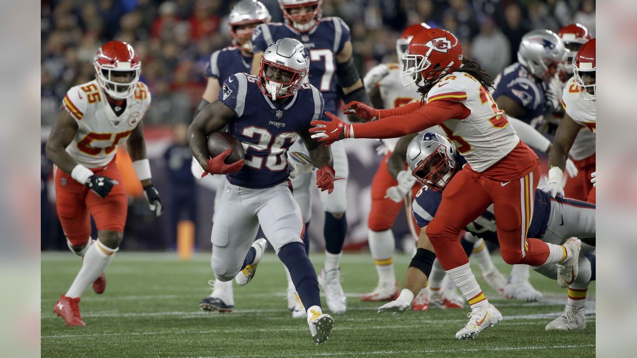 Kansas City Chiefs running back Kareem Hunt (27) gives a stiff arm to New  England Patriots defensive back Devin McCourty (32) as he runs for yardage  during the first half of an