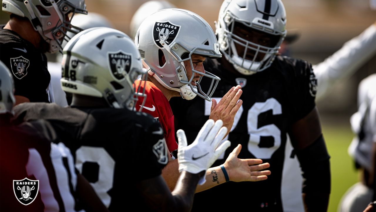 Oakland Raiders head coach Jon Gruden talks with center Rodney Hudson (61)  and quarterback Derek Carr, left rear, during the second half of an NFL  football game against the Miami Dolphins, Sunday, …