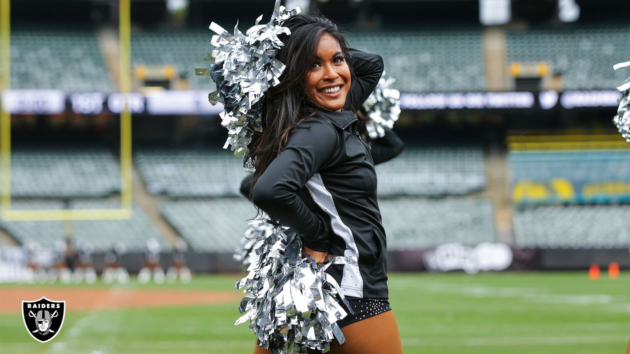 Photo: A Packers cheerleader waves pom poms against the Ravens in