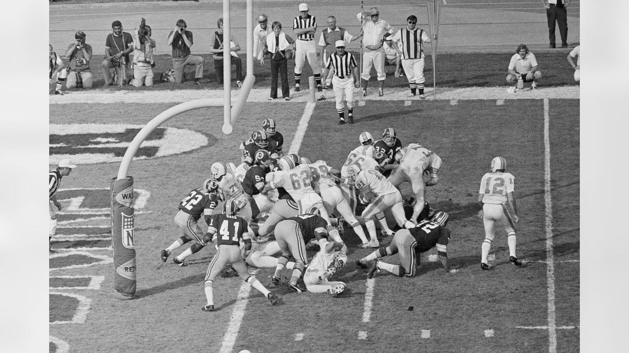 Washington Redskins running back Larry Smith (38) carries the ball during  the game against the Miami Dolphins at RFK Stadium in Washington, DC on  October 13, 1974. Pictured from left to right