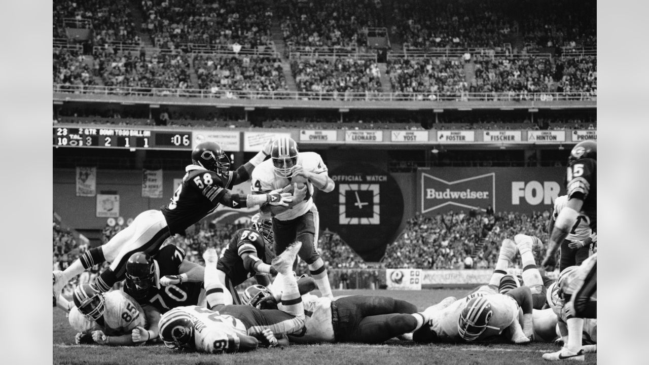 Los Angeles running back Marcus Allen (32) tries to break away from  Washington Redskins Dave Butz (65) as Rich Milot (57) looks on during the  first half of their game at R.F.K.