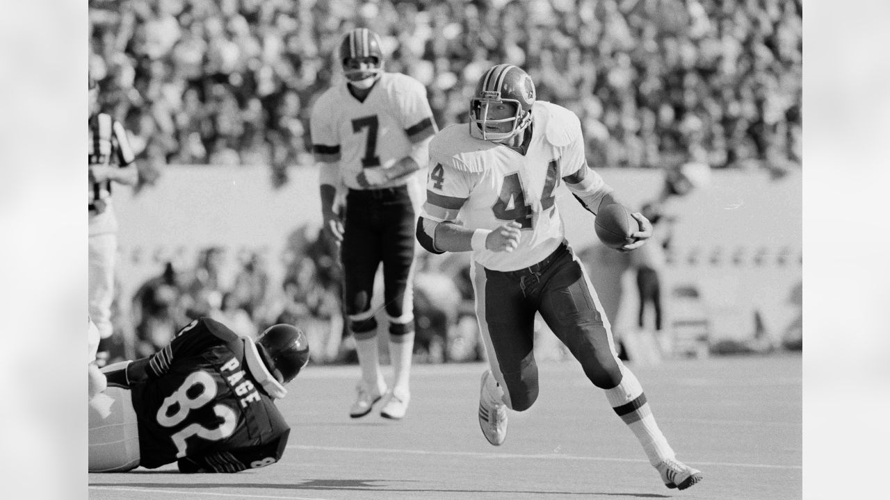 Washington Redskins running back John Riggins (44) gains yardage during  third quarter action in Chicago against the Chicago Bears as Bears' Rueben  Hernderson, right, looks on, Oct. 11, 1981. (AP Photo/Jim Bourdier