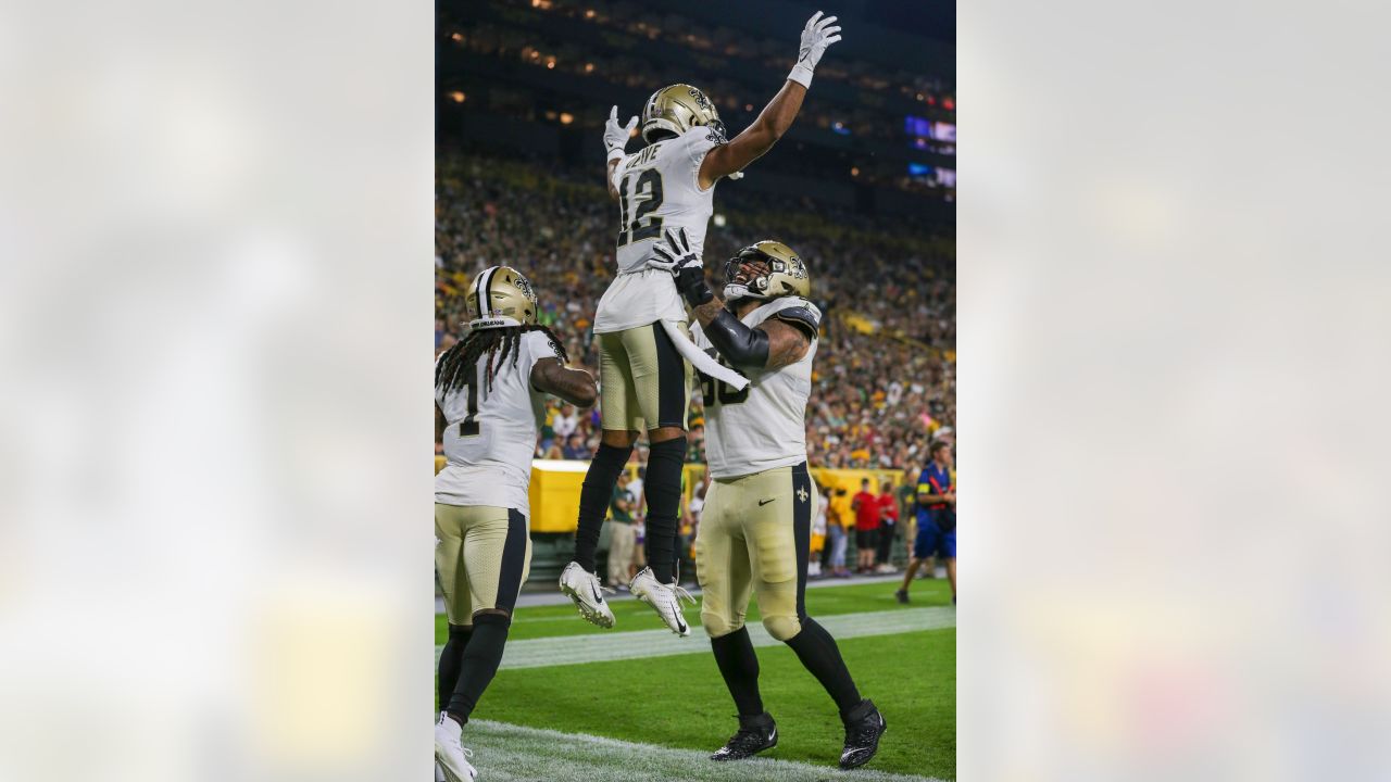 New Orleans Saints wide receiver Chris Olave (12) scores on a touchdown  reception, his first in the NFL, during the first half of a preseason NFL  football game against the Green Bay