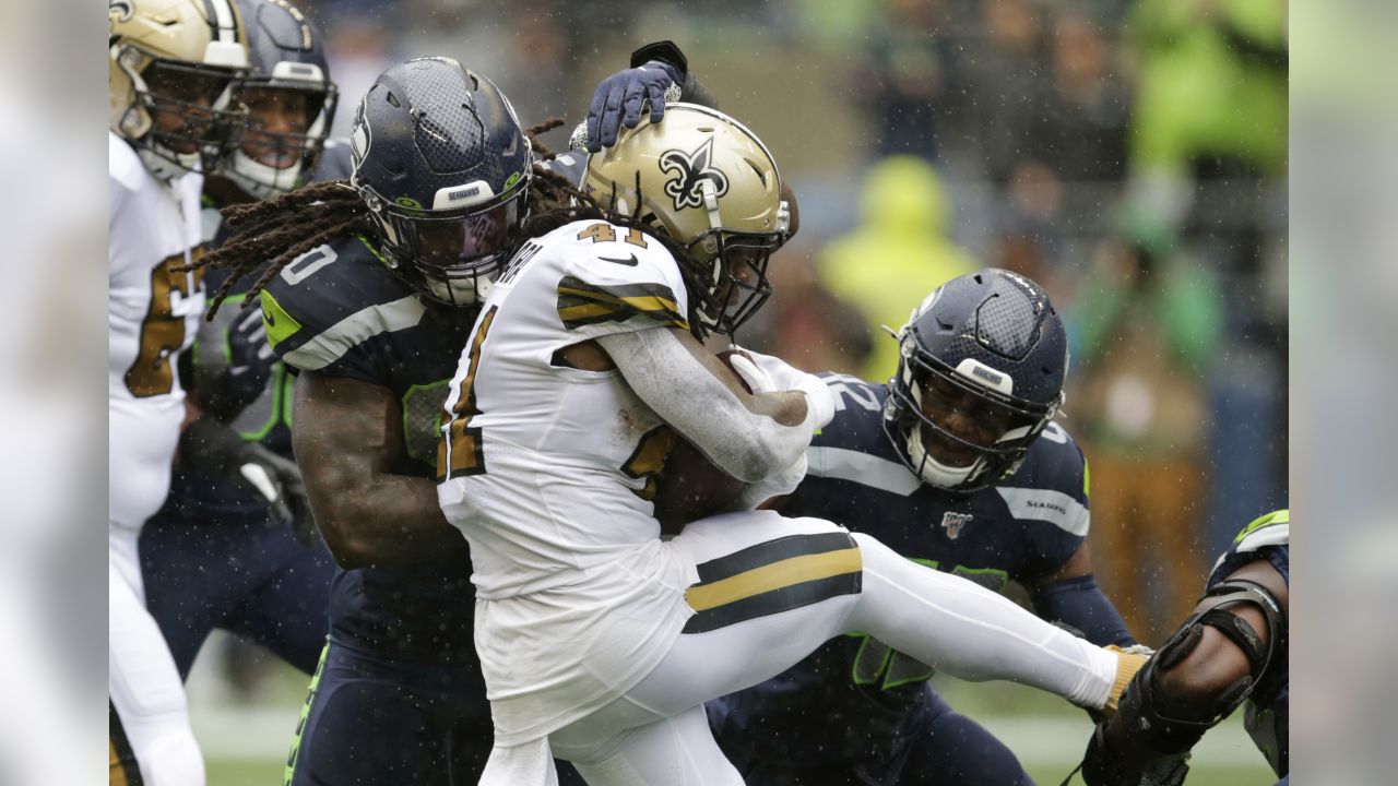 Seattle Seahawks' Jadeveon Clowney, left, and Lano Hill move in on New Orleans Saints' Alvin Kamara on a carry during the first half of an NFL football game, Sunday, Sept. 22, 2019, in Seattle. (AP Photo/Scott Eklund)
