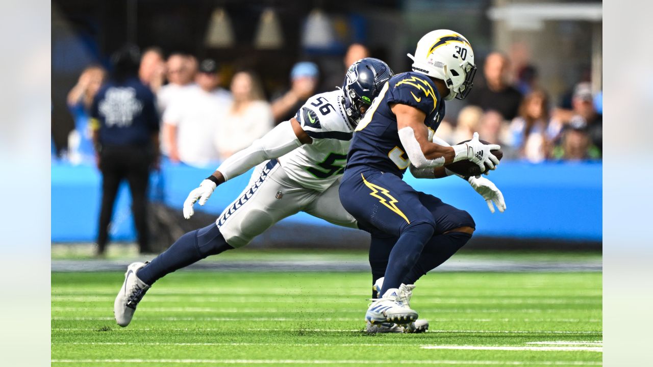 Los Angeles Chargers quarterback Justin Herbert (10) adjusts his helmet as  he warms up before an NFL football game against the Seattle Seahawks  Sunday, Oct. 23, 2022, in Inglewood, Calif. (AP Photo/Marcio