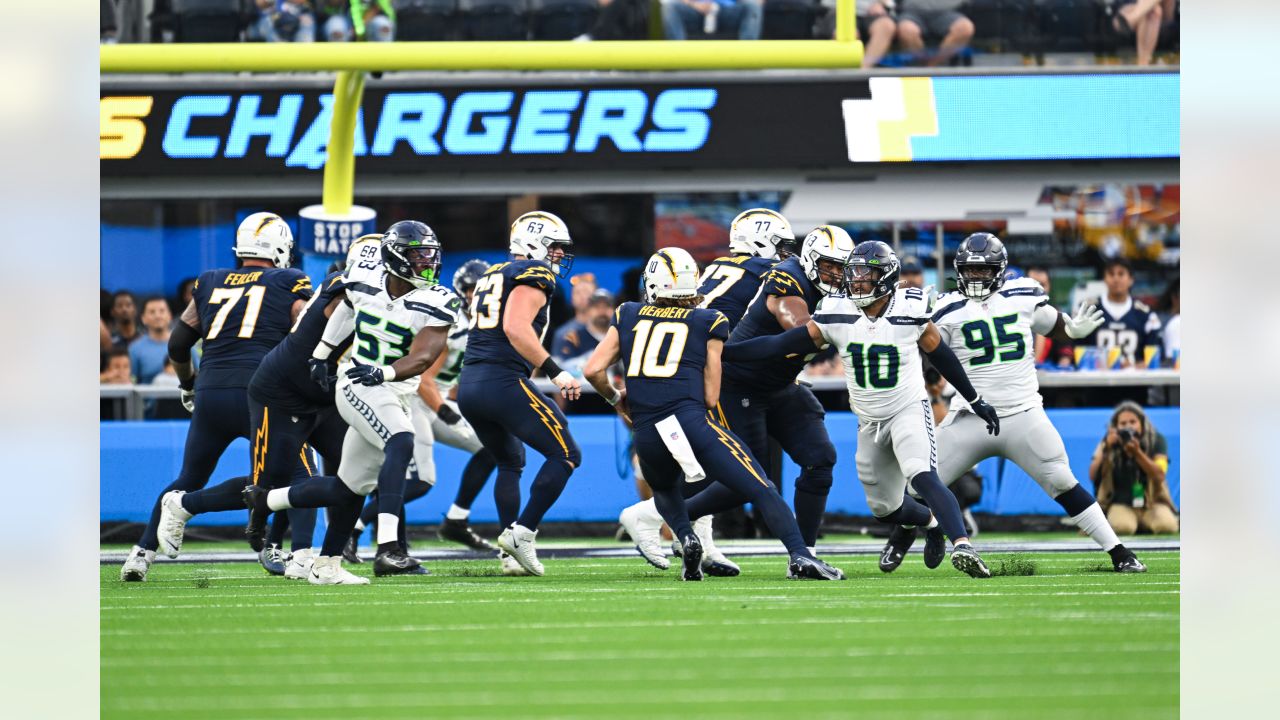 Los Angeles Chargers quarterback Justin Herbert (10) adjusts his helmet as  he warms up before an NFL football game against the Seattle Seahawks Sunday,  Oct. 23, 2022, in Inglewood, Calif. (AP Photo/Marcio