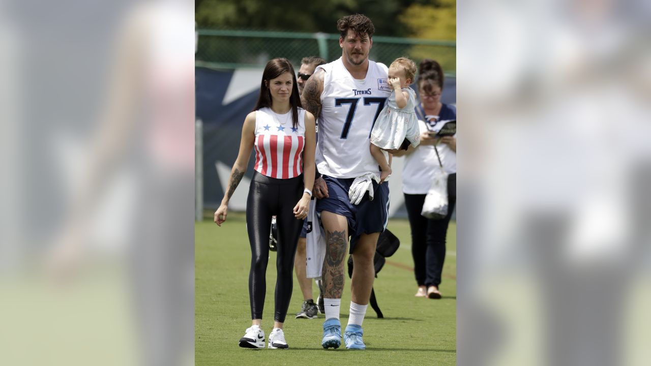 Tennessee Titans offensive tackle Taylor Lewan carries his daughter, Wynne,  1, as he leaves the field following the first day of practice at NFL  football training camp Thursday, July 26, 2018, in