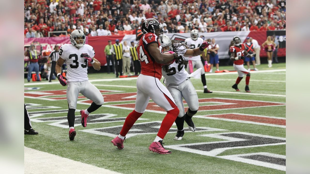 Atlanta Falcons wide receiver Roddy White (84) pulls defender Oakland  Raiders cornerback Michael Huff (24) during