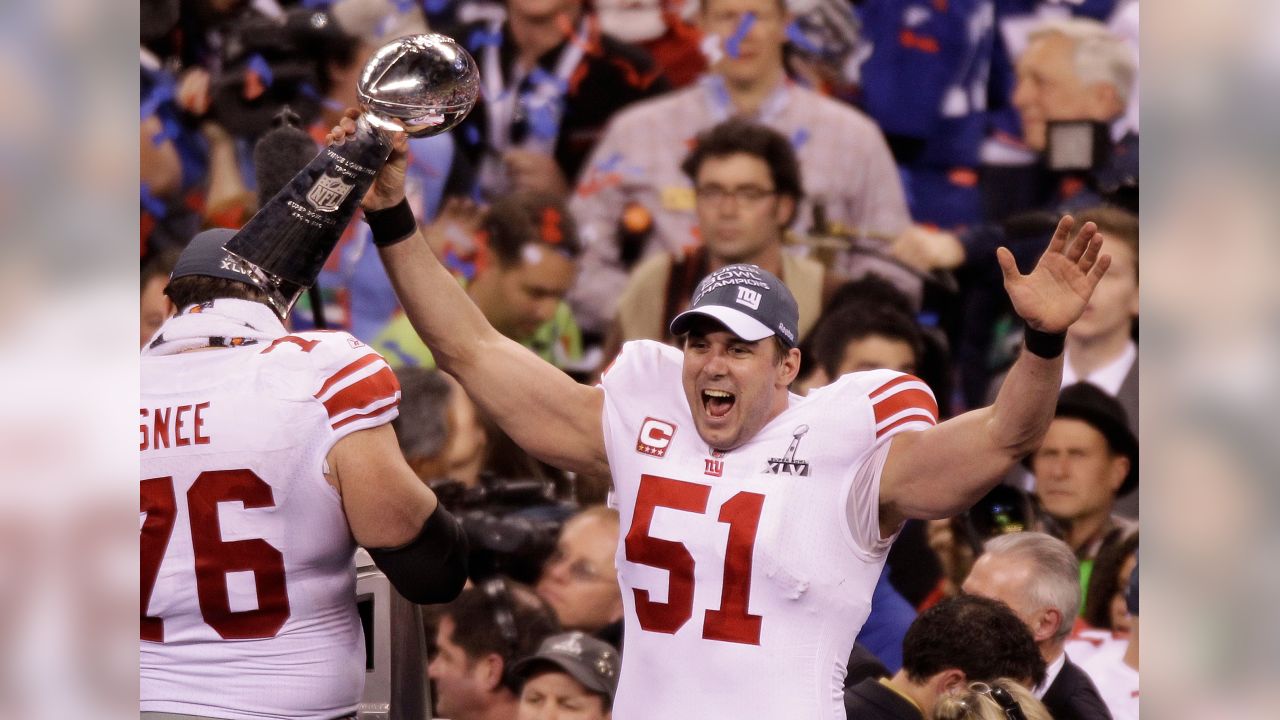 New York Giants line backer Zak DeOssie holds up a newspaper proclaiming  the Giants' win over the New England Patriots at Super Bowl XLII at  University of Phoenix Stadium in Glendale, Arizona