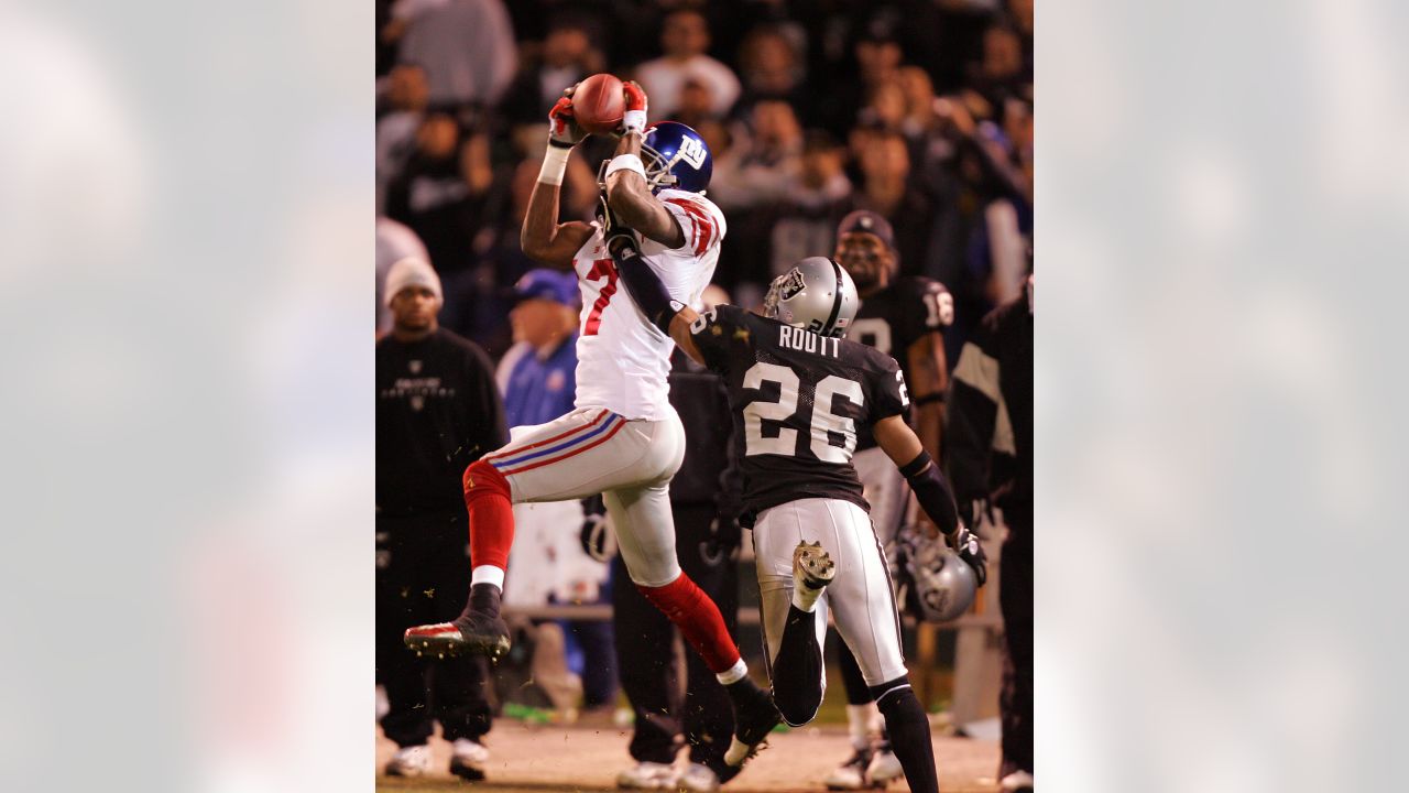 New York Giants Plaxico Burress catches a 52 yard pass over New England  Patriots (27) Ellis Hobbs III in the first quarter at Giants Stadium in  East Rutherford, New Jersey on December