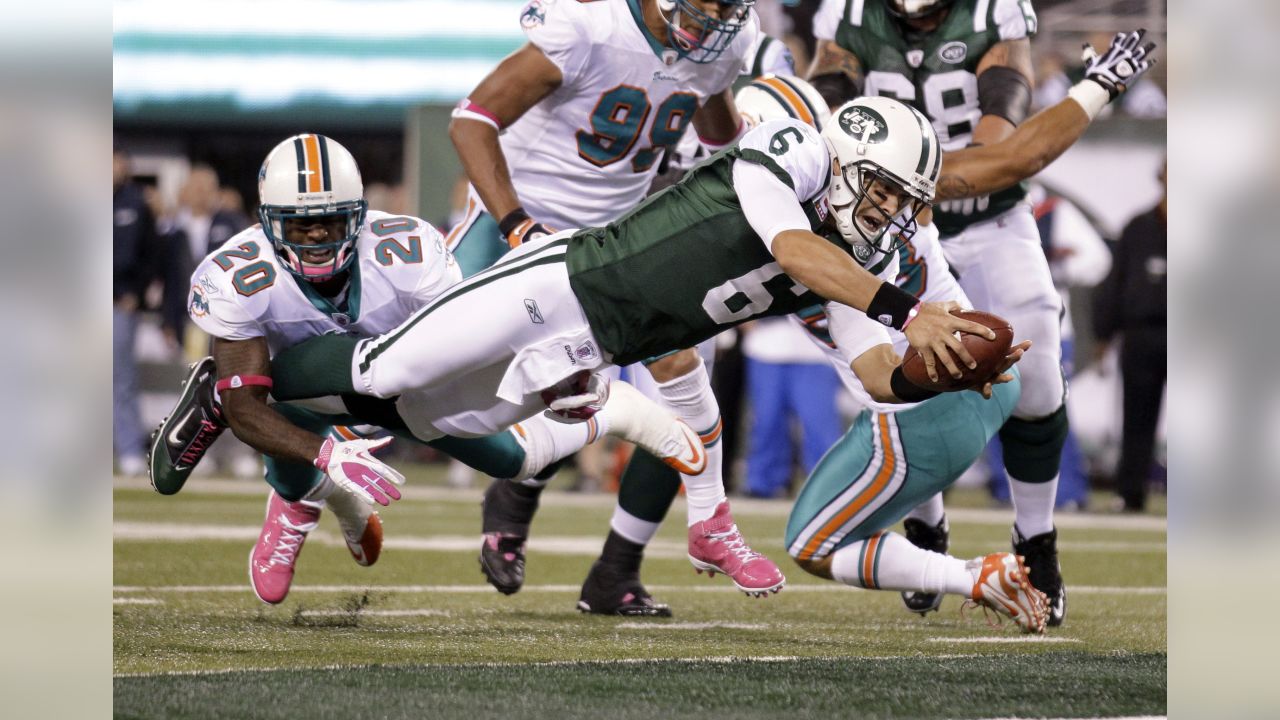 FILE - New York Jets Ronnie Lott (42) and Jeff Lageman, left, bring down Miami  Dolphins Mark Higgs (21) during the first half of an NFL football game in  Miami, Sept. 12