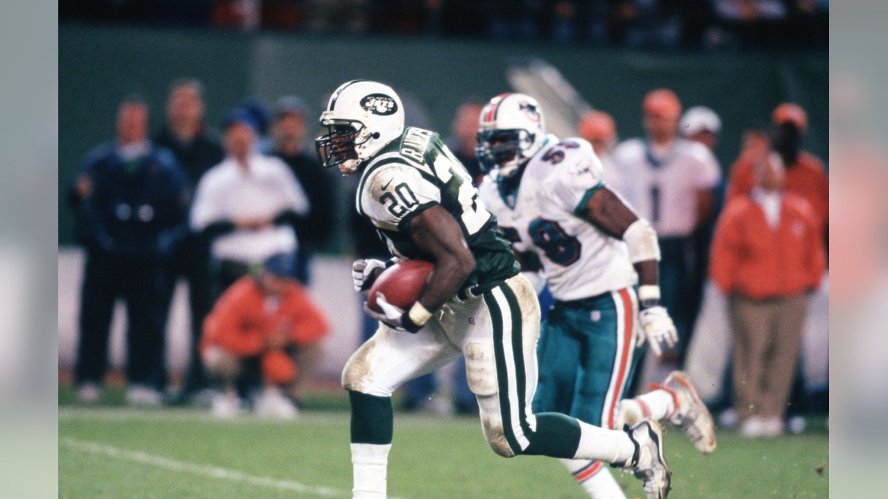 FILE - New York Jets Ronnie Lott (42) and Jeff Lageman, left, bring down  Miami Dolphins Mark Higgs (21) during the first half of an NFL football  game in Miami, Sept. 12