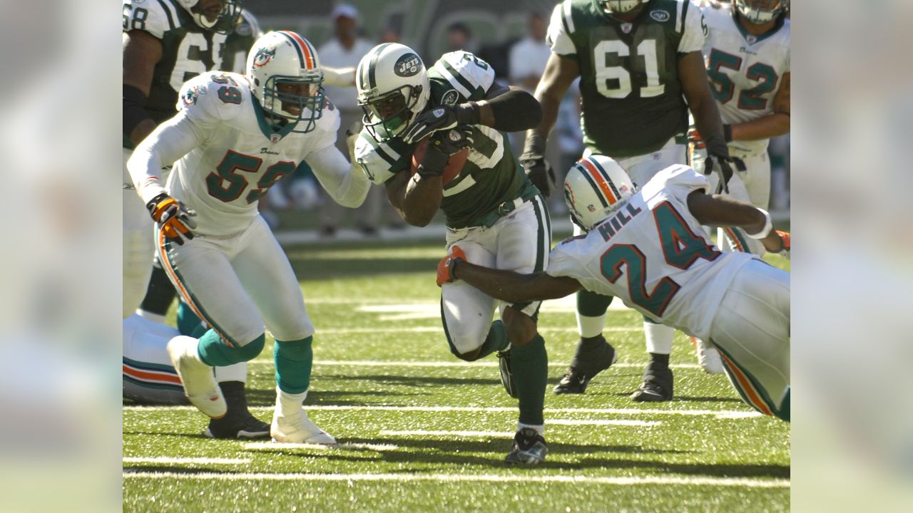 FILE - New York Jets Ronnie Lott (42) and Jeff Lageman, left, bring down  Miami Dolphins Mark Higgs (21) during the first half of an NFL football  game in Miami, Sept. 12