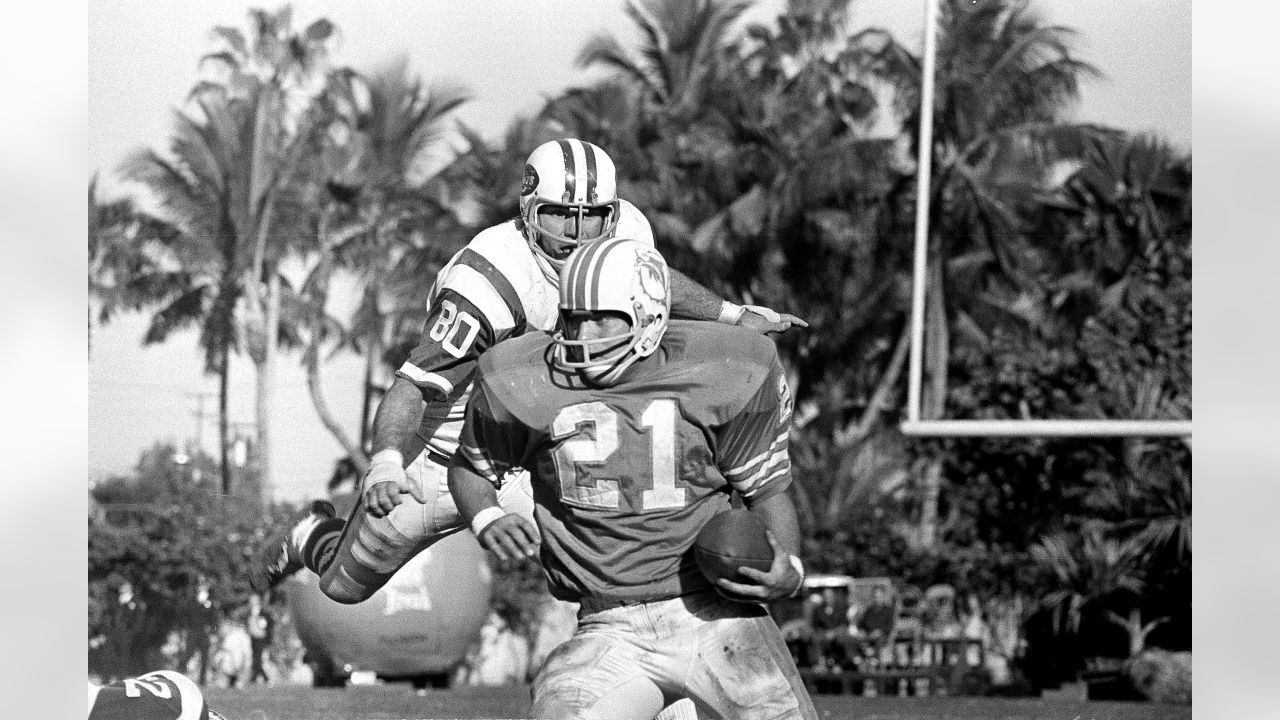 FILE - New York Jets Ronnie Lott (42) and Jeff Lageman, left, bring down  Miami Dolphins Mark Higgs (21) during the first half of an NFL football  game in Miami, Sept. 12