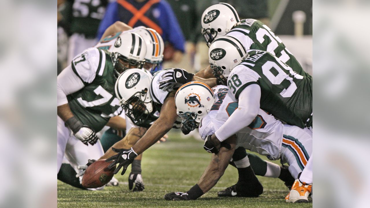 The New York Jets' Victor Hobson (54) tackles Miami Dolphins ball carrier Ronnie  Brown (23) during game action. The Jets defeated the Dolphins, 31-28, at  Giants Stadium in East Rutherford, New Jersey