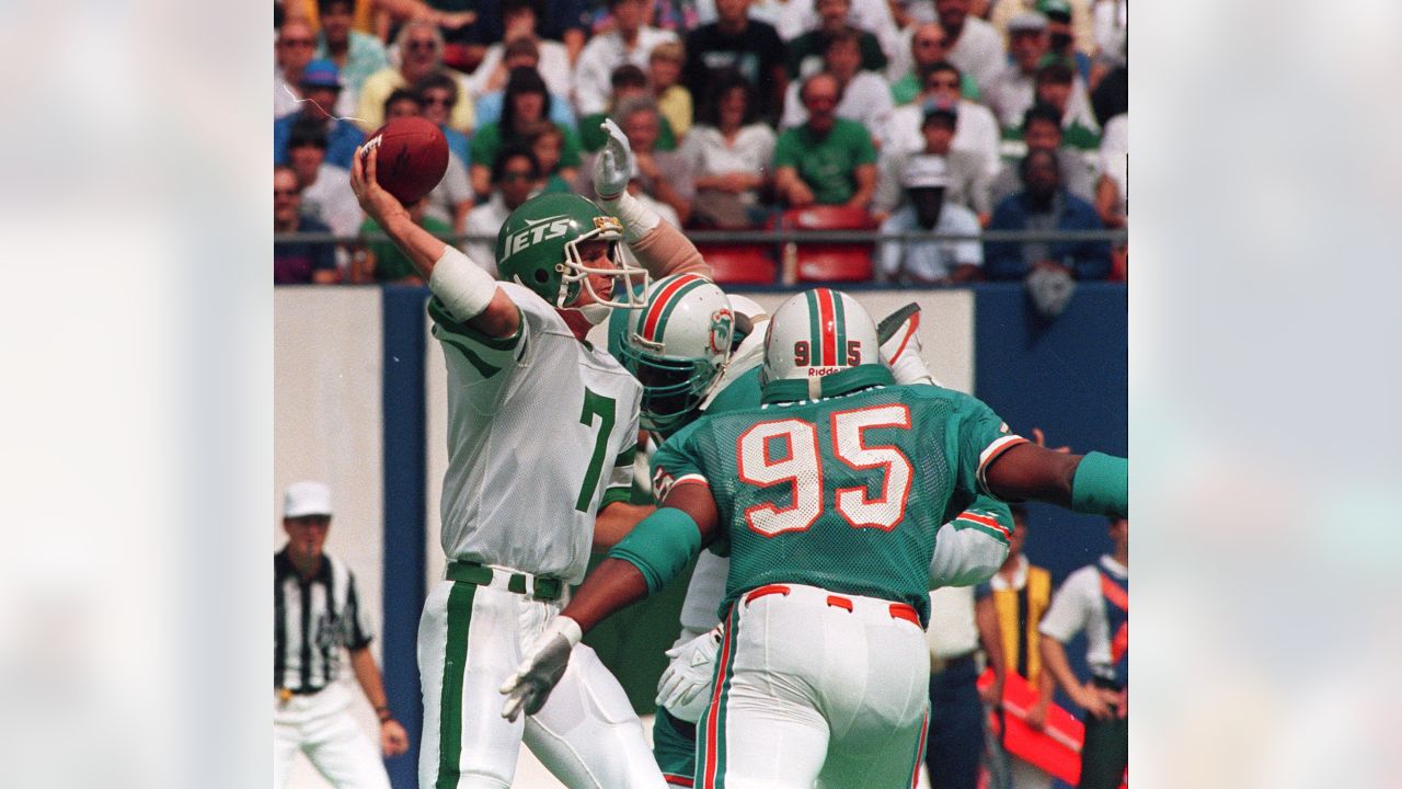 Miami Dolphin back Jim Kiick (21) seems totally unaware that he is about to  be trounced by New York Jets John Elliott (80) during action in their AFL  game Sunday afternoon Dec.