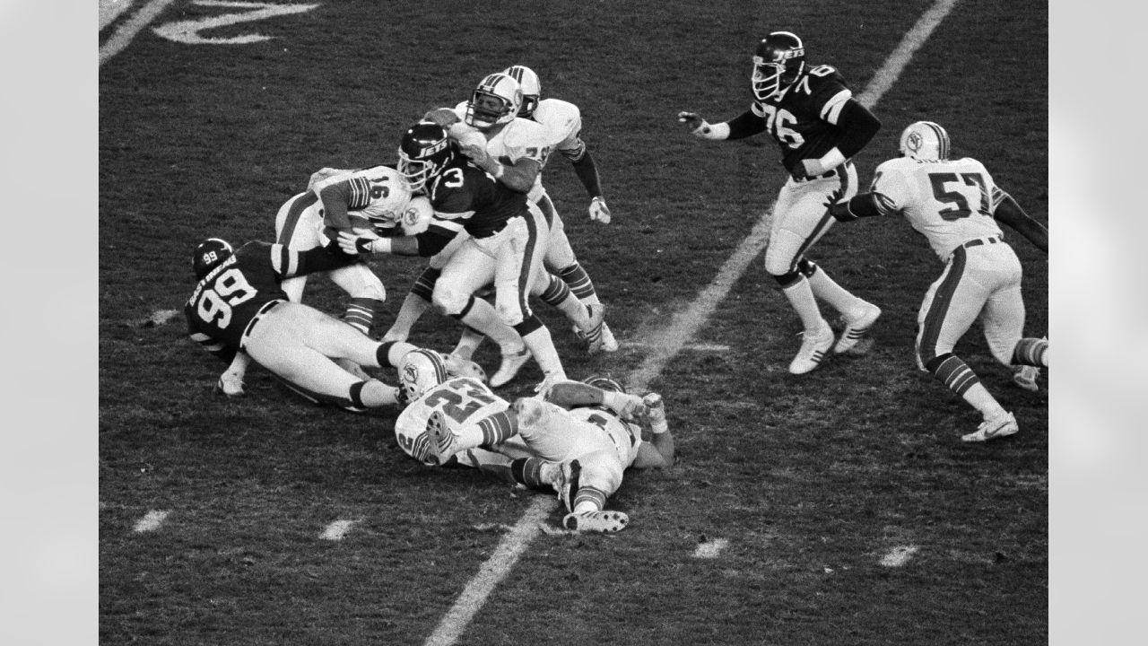 Miami Dolphin back Jim Kiick (21) seems totally unaware that he is about to  be trounced by New York Jets John Elliott (80) during action in their AFL  game Sunday afternoon Dec.