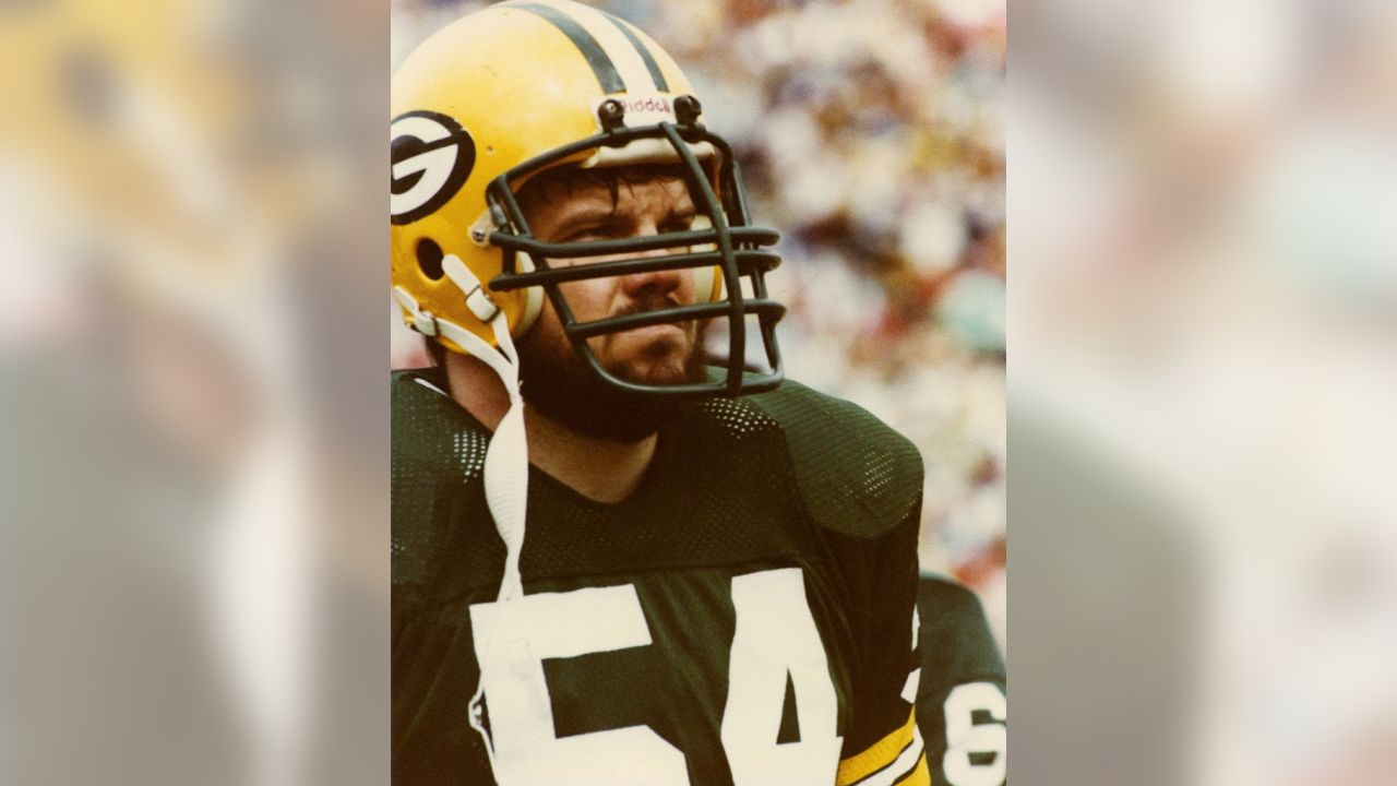 Former Green Bay Packer Larry McCarren smiles as he signs an