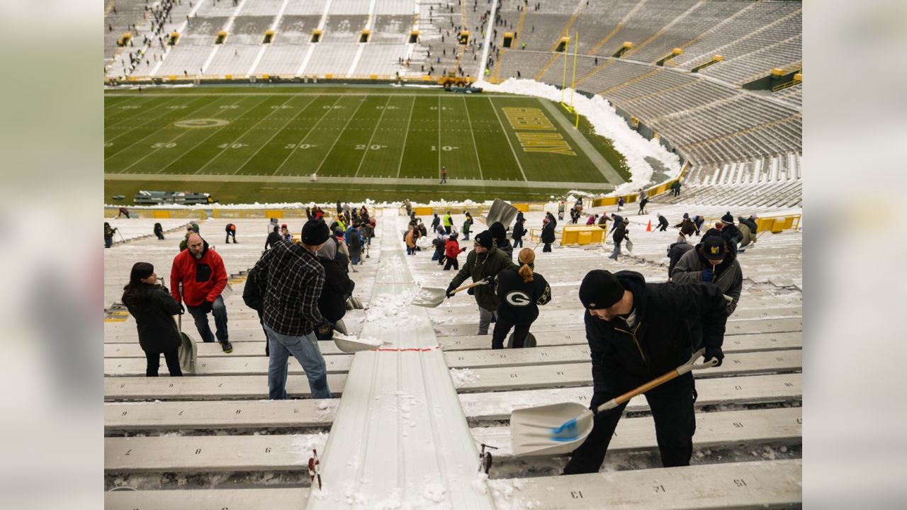 Fans shovel the frozen tundra of Lambeau Field