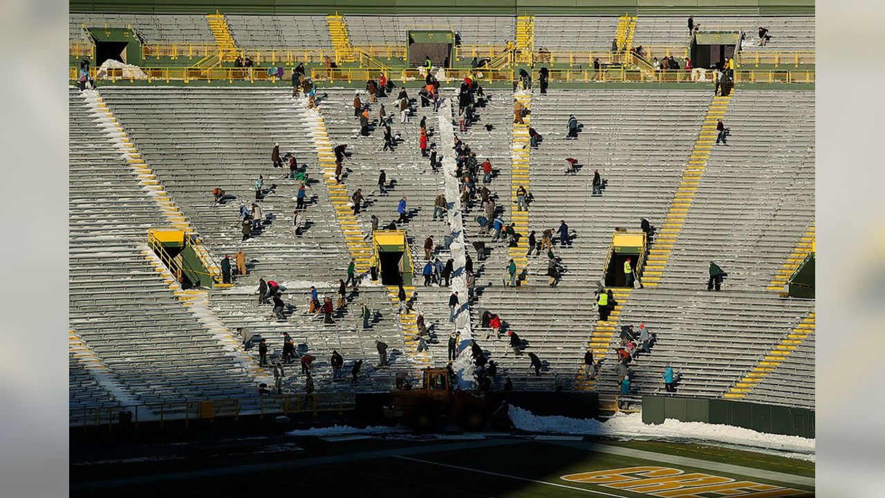 Fans shovel the frozen tundra of Lambeau Field