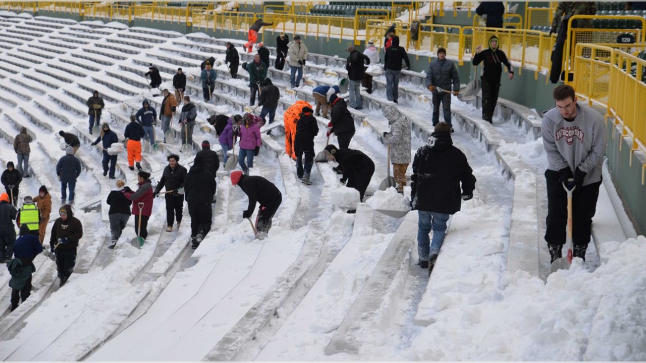 Fans shovel the frozen tundra of Lambeau Field