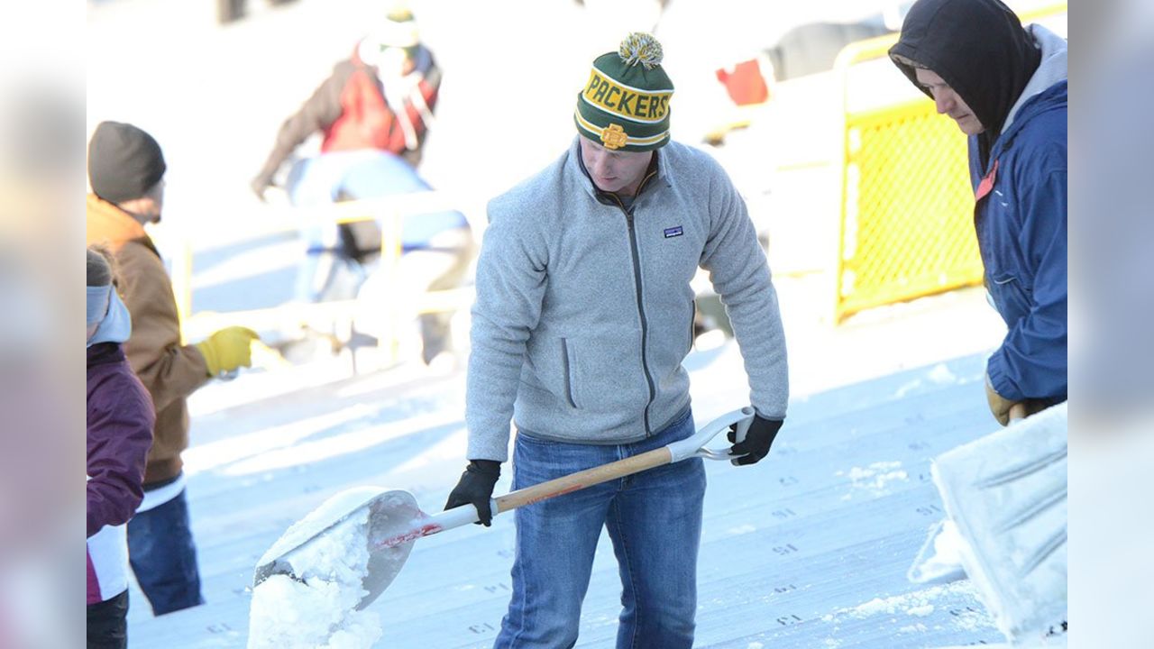 Fans shovel the frozen tundra of Lambeau Field