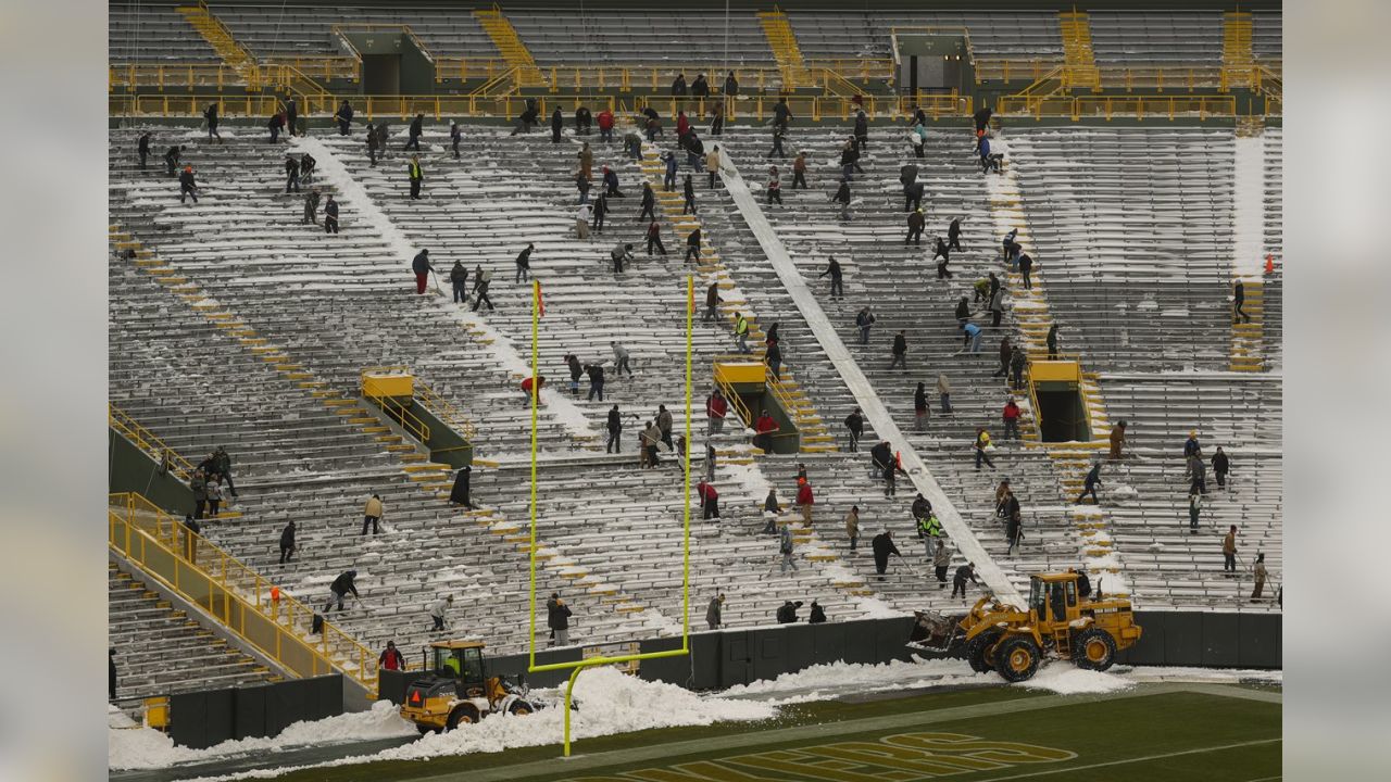 Fans shovel the frozen tundra of Lambeau Field