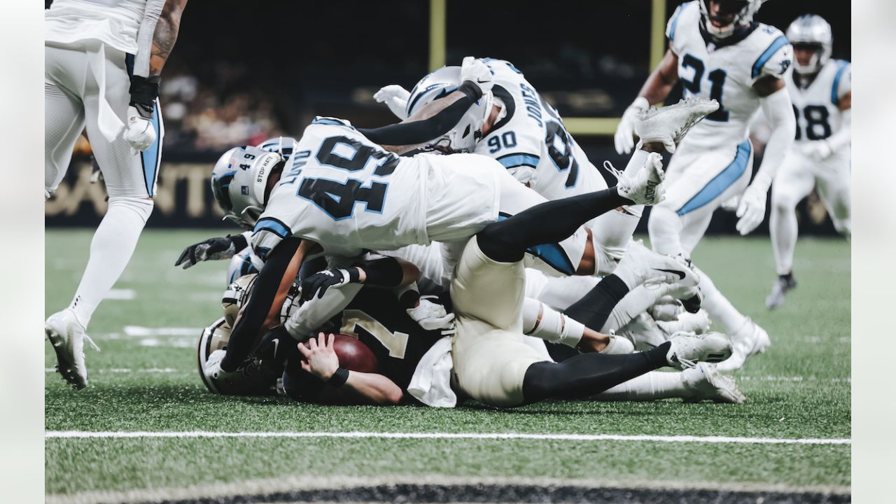 Frankie Luvu of the Carolina Panthers tackles Tom Brady of the