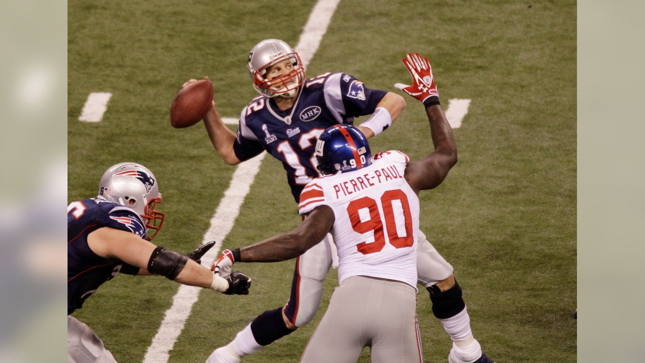 New England Patriots quarterback Tom Brady is hit by New York Giants  defensive end Justin Tuck as he throws a pass down field during Super Bowl  XLVI February 5, 2012, in Indianapolis.