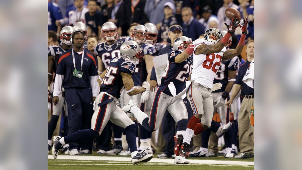 New York Giants wide receiver Victor Cruz (C) catches a two-yard touchdown  pass against New England Patriots safety James Ihedigbo during the first  quarter at Super Bowl XLVI at Lucas Oil Stadium