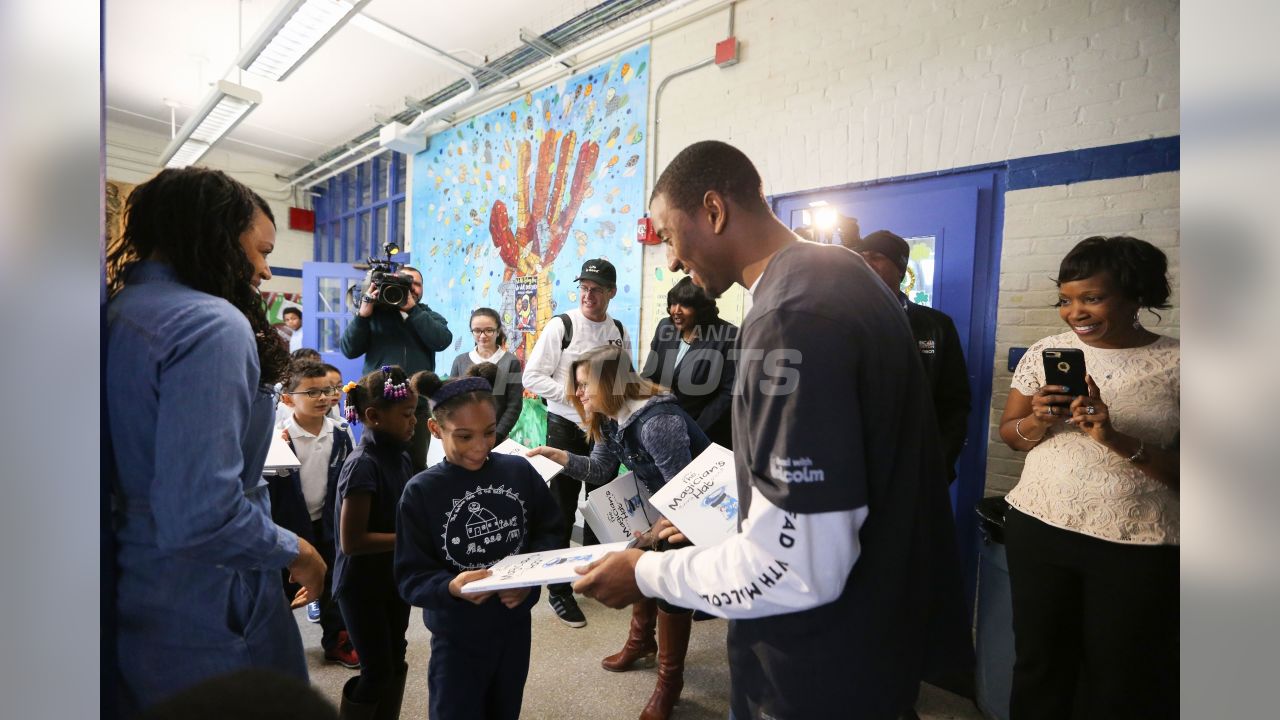 New England Patriot Malcolm Mitchell surprises students with books