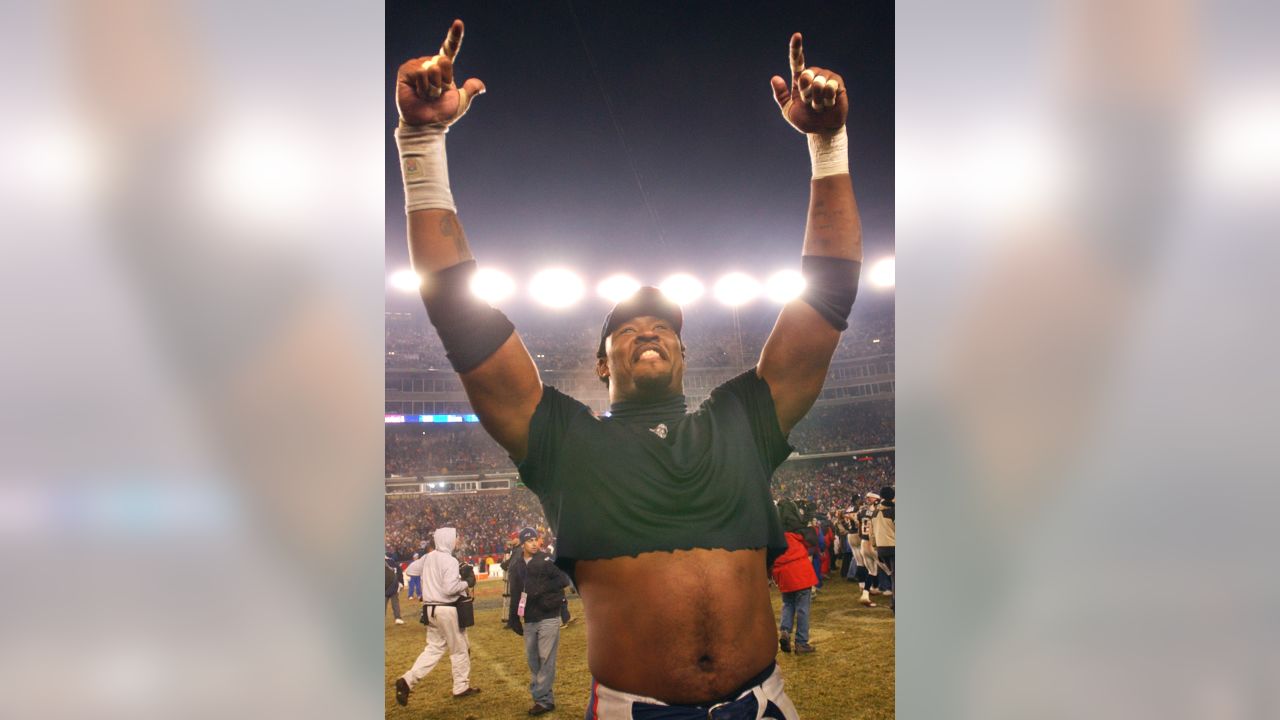 Willie McGinst, of the New England Patriots, holds up the AFC Championship  Trophy, as he walks around the field, at Gillette Stadium, following the  Patriots victory of the Indianapolis Colts, in the