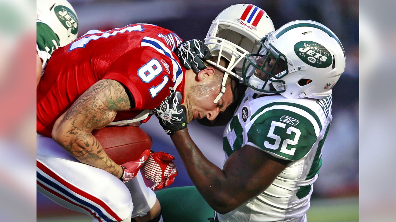 New England Patriots' Aaron Hernandez (81) is tackled by New York Jets'  Kyle Wilson (20) and Jim Leonhard (36) during the third quarter of an NFL  football game Sunday, Nov. 13, 2011