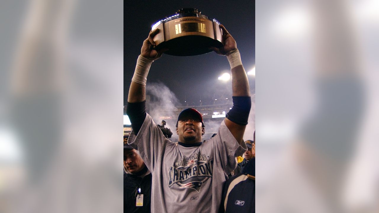 Willie McGinst, of the New England Patriots, holds up the AFC Championship  Trophy, as he walks around the field, at Gillette Stadium, following the  Patriots victory of the Indianapolis Colts, in the