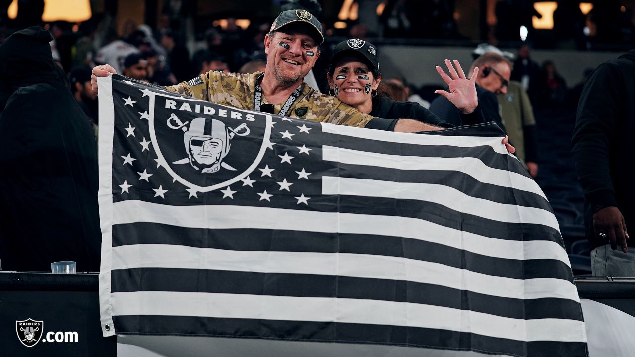 Fans wave team flags at an NFL game between the Oakland Raiders and the  Chicago Bears at Totten …