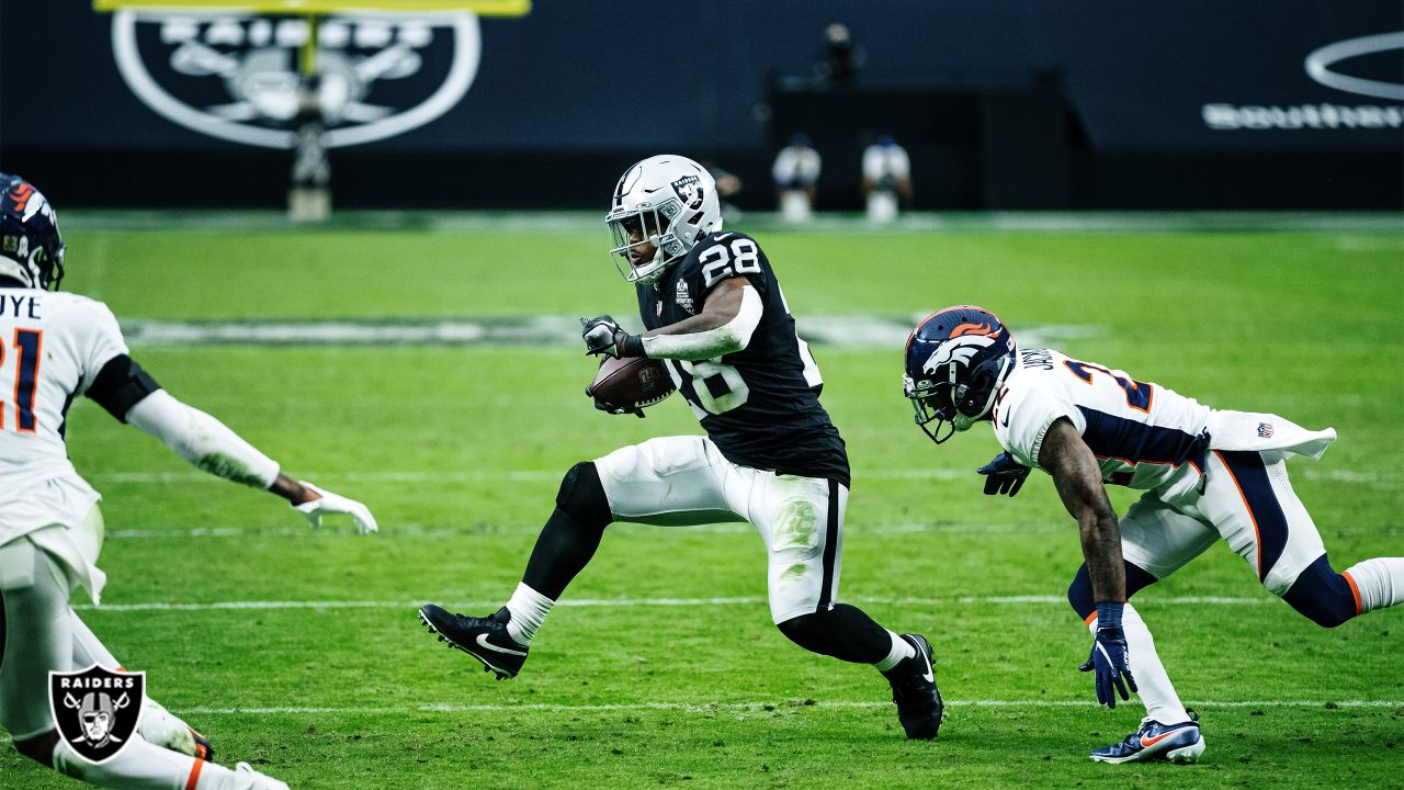 Las Vegas Raiders running back Josh Jacobs (28, left) jokes around with  head coach Jon Gruden d …