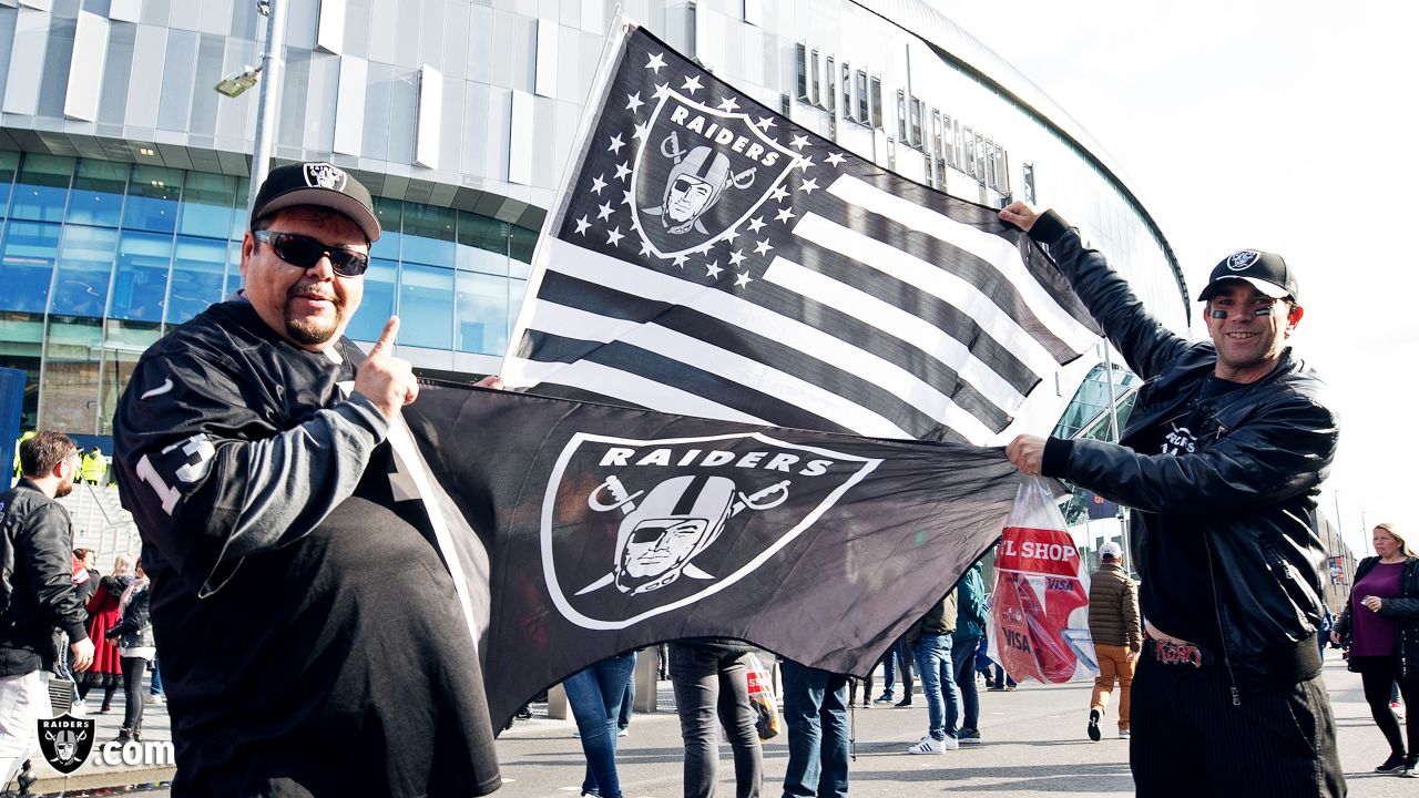 Fans wave team flags at an NFL game between the Oakland Raiders and the  Chicago Bears at Totten …